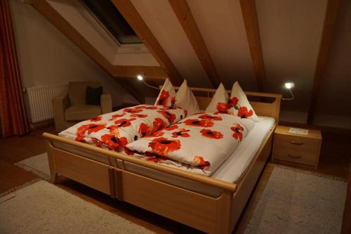 ein Schlafzimmer mit einem Bett mit roten Blumen darauf in der Unterkunft Schmiedlehnerhof in Birnberg