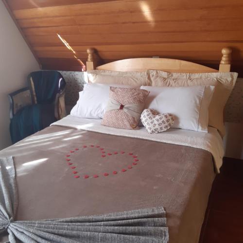 a bed with a heart made out of pillows at SILVÉRIOS Suítes DA MONTANHA in Campos do Jordão