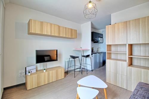 un salon avec une télévision et une cuisine dans l'établissement Studio très récent au cœur des Minimes avec linge fourni, à La Rochelle