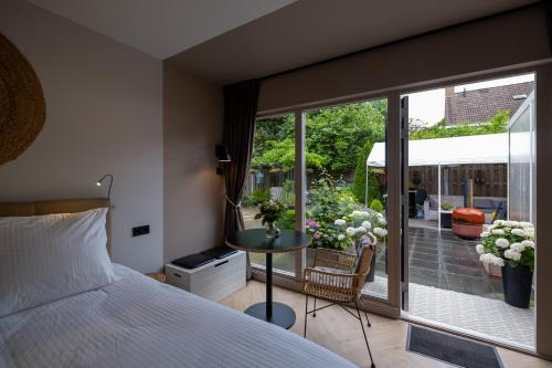 a bedroom with a bed and a view of a patio at B&B de Hoek in Hoek van Holland