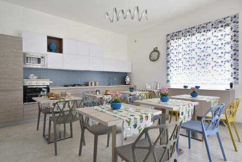 een eetkamer met tafels en stoelen in een keuken bij Casa Salemi - Western Sicily Home in Salemi