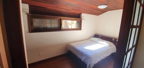 una piccola camera con letto e finestra di Casa no coração de gramado a Gramado