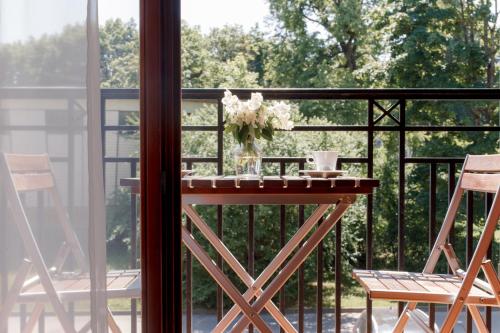 a balcony with a table and two chairs and a window at Regina in Druskininkai