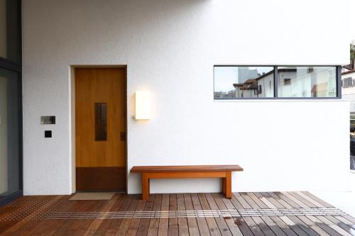 a room with a wooden bench and a door at MUSTARD HOTEL SHIMOKITAZAWA in Tokyo