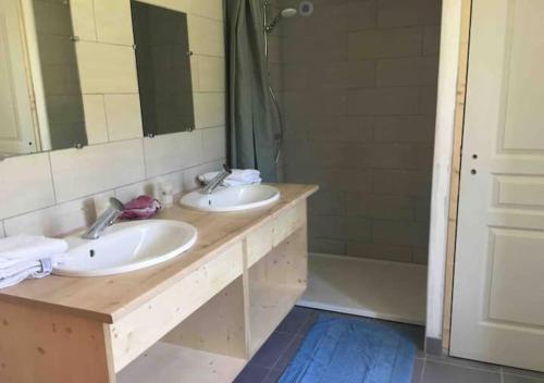 ein Badezimmer mit zwei Waschbecken, einem Spiegel und einer Dusche in der Unterkunft Dormez dans la chambre du meunier ! in Germolles-sur-Grosne
