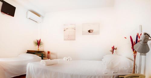Habitación blanca con 2 camas y TV. en Hotel Blumen, en San Benedetto del Tronto