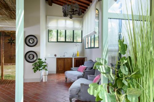 a living room filled with furniture and plants at Borgo I Vicelli Country Relais in Bagno a Ripoli