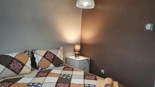 a bedroom with a bed with pillows and a lamp at Apartament Anielki in Malbork