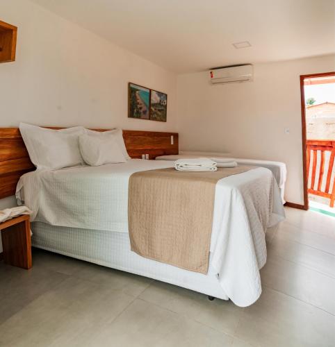 a bedroom with a large bed and a window at Pousada Ricoco in São Miguel dos Milagres