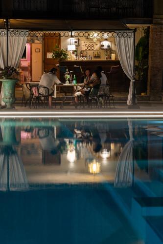a pool of water with people sitting at a restaurant at Borgo I Vicelli Adults Only Relais in Bagno a Ripoli