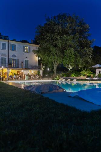 a swimming pool in front of a building at night at Borgo I Vicelli Adults Only Relais in Bagno a Ripoli