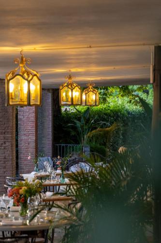 a dining room with tables and chandeliers at Borgo I Vicelli Adults Only Relais in Bagno a Ripoli