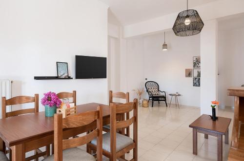 a dining room and living room with a table and chairs at Artemis Apartments in Stalos