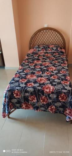 una cama con un edredón floral encima en Ioannis - Zimmer mit Zugang zu Terrasse, en Gavrolímni