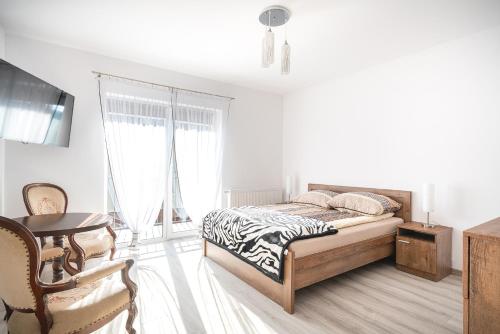 a white bedroom with a bed and a table at JULIA in Reda