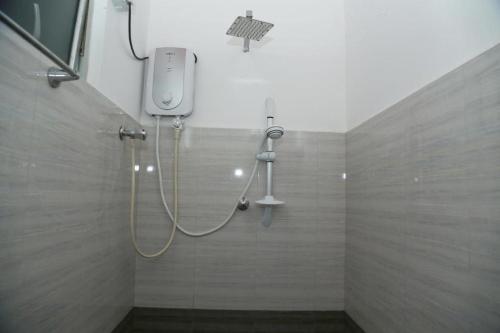 a shower with a shower head in a bathroom at Omee Guest in Mirissa