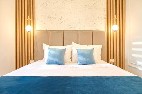 a bedroom with a bed with blue and white pillows at EEE Apart Boutique in Constanţa