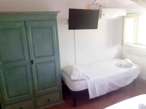 a small bedroom with a bed and a green cabinet at Agriturismo Tre Morene in Monteforte Cilento