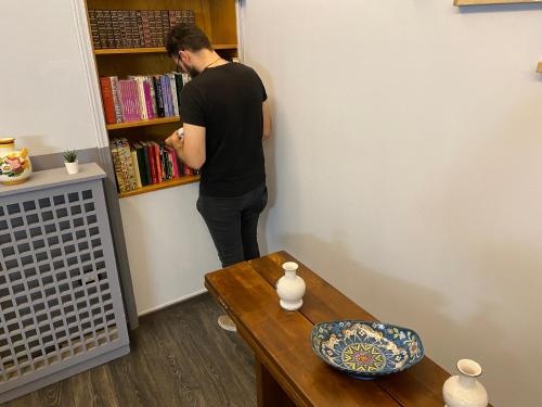 a man is looking in a book shelf at Hotel Gioia in Florence