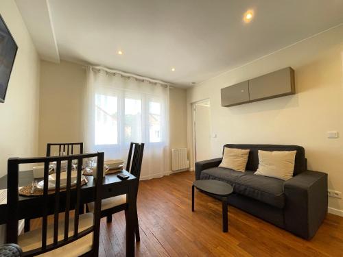 a living room with a couch and a table at Appart'Village Jouy Les Metz in Jouy-en-Josas