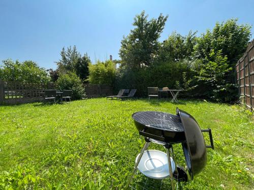 a barbecue grill sitting in the grass in a yard at Appart'Village Jouy Les Metz in Jouy-en-Josas