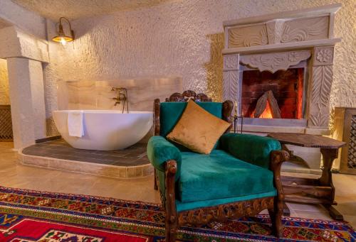 a living room with a tub and a chair and a fireplace at Helen Cave Suites in Göreme