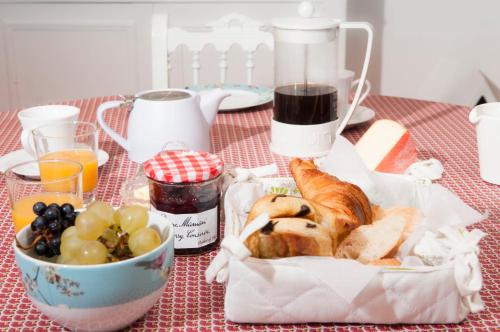 una mesa cubierta con una cesta de pan y un bol de fruta en Sinti, en Saint-Hilaire-dʼOzilhan