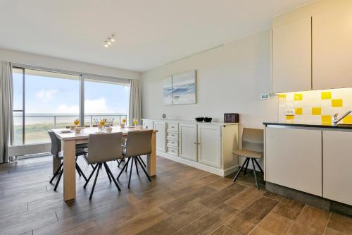 cocina con mesa y sillas en una habitación en Flat Fleur, en De Panne