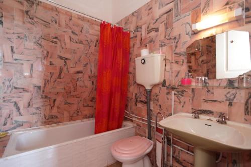 a bathroom with a red shower curtain and a toilet and sink at Casa Grande Portugal in Burgau