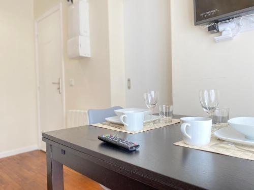 a table with a remote control sitting on top of it at Appart'Village Jouy Les Metz in Jouy-en-Josas
