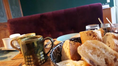 a plate of bread on a table with a cup of coffee at chambres d'hôtes Le Carillon in Bergues