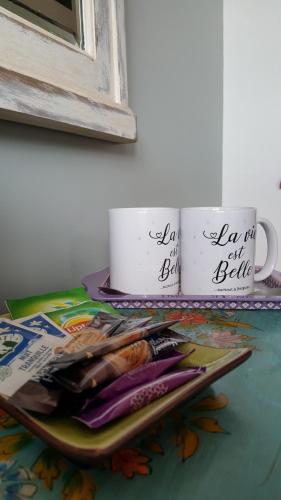 two coffee cups sitting on a table with magazines at chambres d'hôtes Le Carillon in Bergues