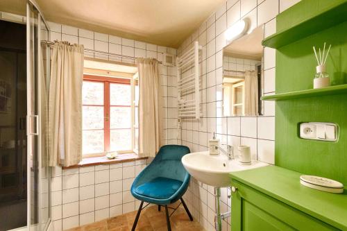 baño verde con lavabo y silla azul en Měšťanský dům - kulturní památka Mlýnská 119, en Jindřichův Hradec