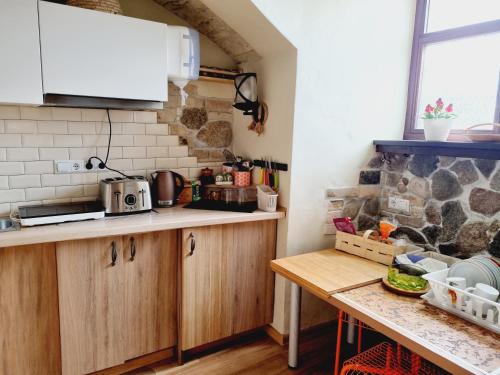a kitchen with wooden cabinets and a wooden table at HelloVilniusHostel in Vilnius