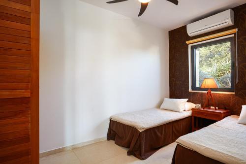 a bedroom with two beds and a window at Villa The Longhouse- Pool-Sauna-Gym- Panormaic Seaview in Sellía