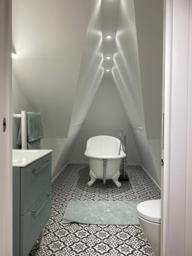 a white bathroom with a tub and a toilet at Villa du bassin -un petit coin de paradis in Andernos-les-Bains