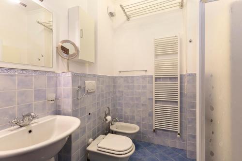 y baño con lavabo, aseo y espejo. en Dolfin - Nel centro di Stresa - By Impero House en Stresa
