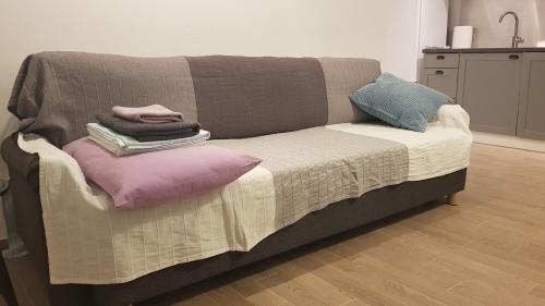 un sofá con mantas y almohadas encima en Stone house apartment in Zlarin centre en Zlarin