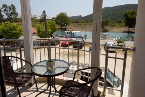 a table and chairs on a balcony with a view of a marina at Golden Sand in Ammoudia
