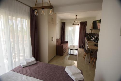 a bedroom with a bed and a living room with a desk at Golden Sand in Ammoudia