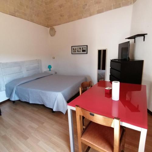 una camera con letto e tavolo rosso di Piazzetta Del Forno - Monolocale ad Assergi