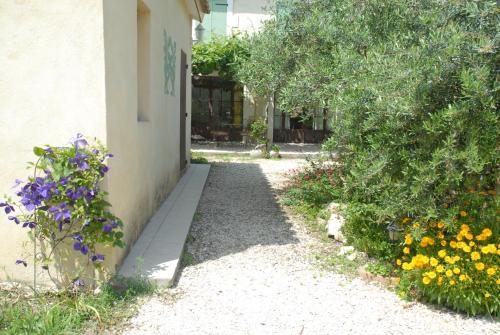 a garden with flowers next to a building at Gîte Du Mas Des Oliviers in Mézoargues