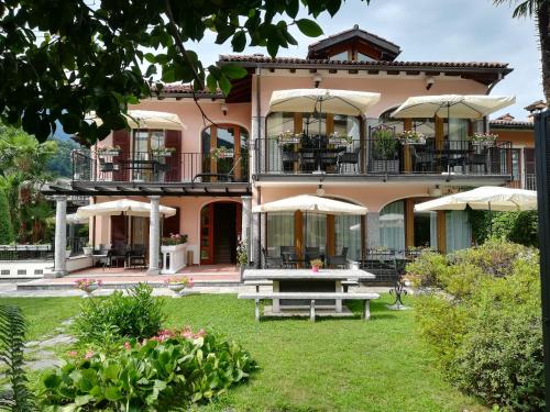a large pink building with a picnic table in front of it at Residence Villa Margherita WITH POOL & HYDROMASSAGE in Cannobio