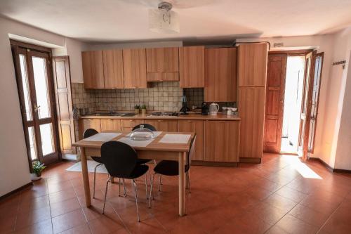 eine Küche mit Holzschränken sowie einem Tisch und Stühlen in der Unterkunft casa dolce casa in Aosta