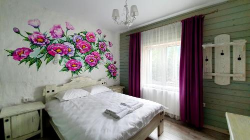 a bedroom with a large flower mural on the wall at Olko House in Yaremche