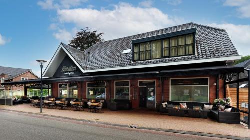 a building with chairs and tables on a street at Hotel Karsten in Norg