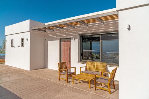 a patio with two chairs and a table on a house at Messinian Riviera Villas in Petalidhion