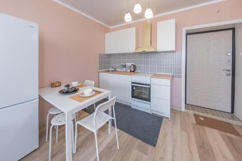 a kitchen with a white table and chairs in it at Go to in Astana