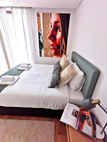 a bedroom with a bed with a painting on the wall at 188 Avenue, Aveiro Centro in Aveiro