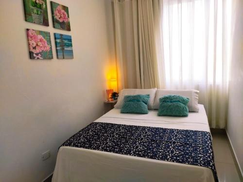 Un dormitorio con una cama con almohadas verdes. en Lindo apto Balneário Camboriú 2 quartos Av BRASIL, en Balneário Camboriú